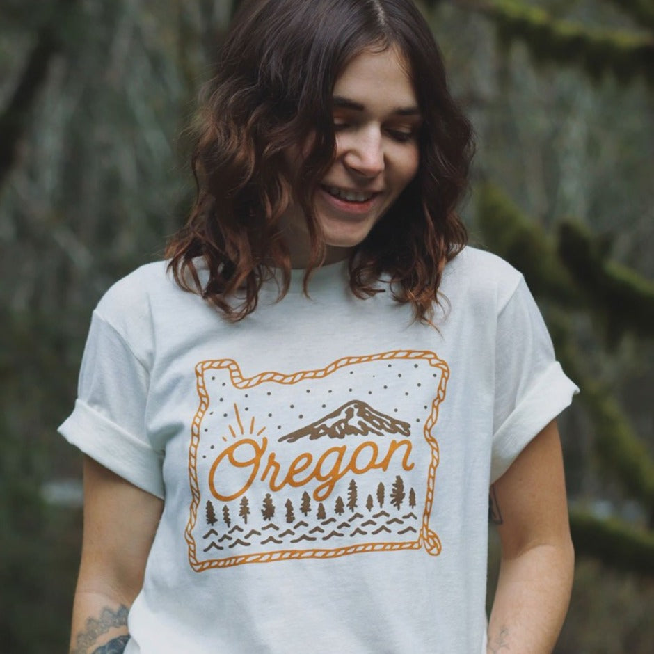 Person wearing TLE white Oregon Lasso shirt