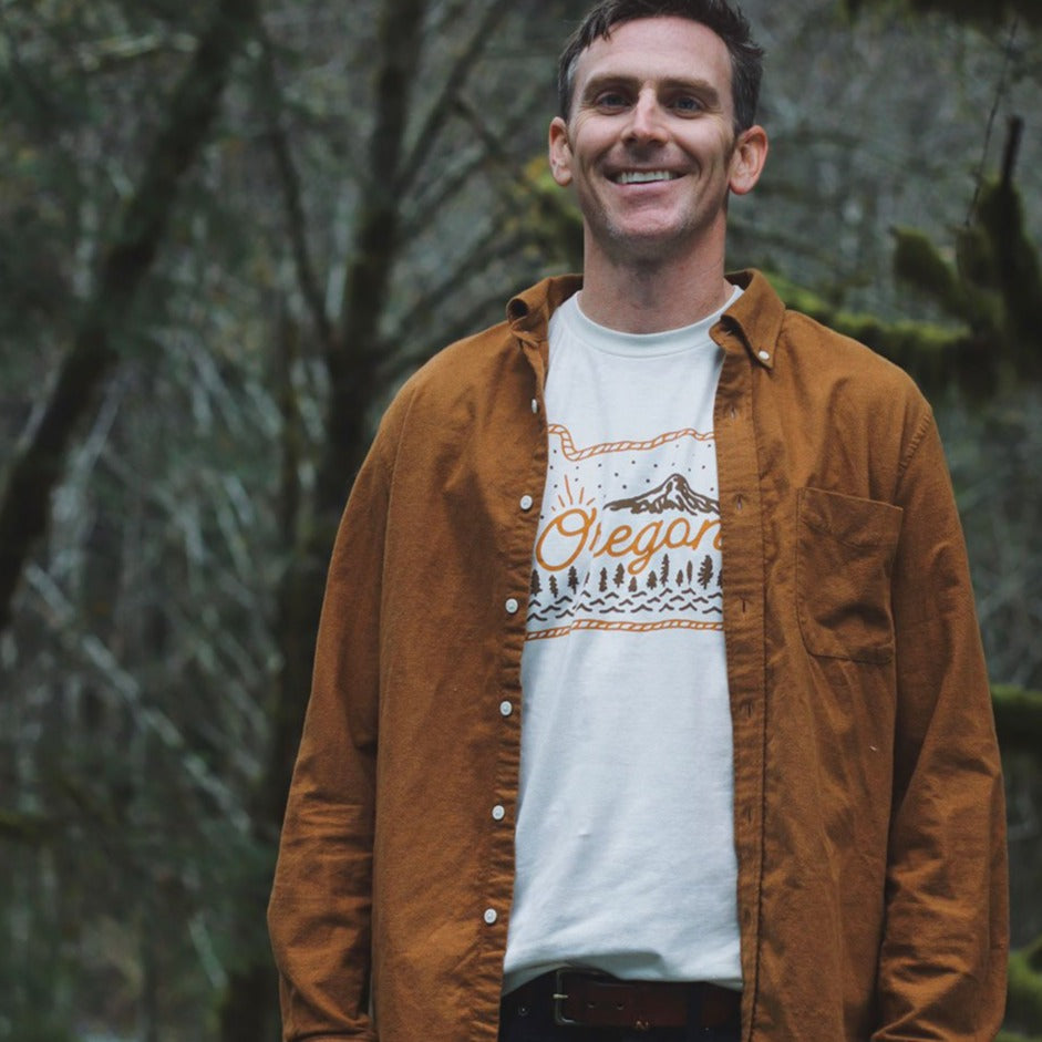 Person wearing TLE white Oregon Lasso shirt